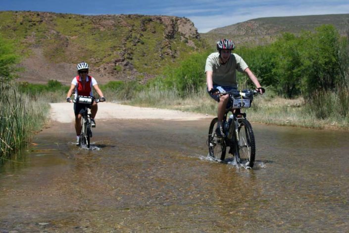 ABC bike and hike challenge – Bikers pushes through on their bikes to cross a flooded road. ABC bike and hike challenge - Bikers pushes through on their bikes to cross a flooded road.